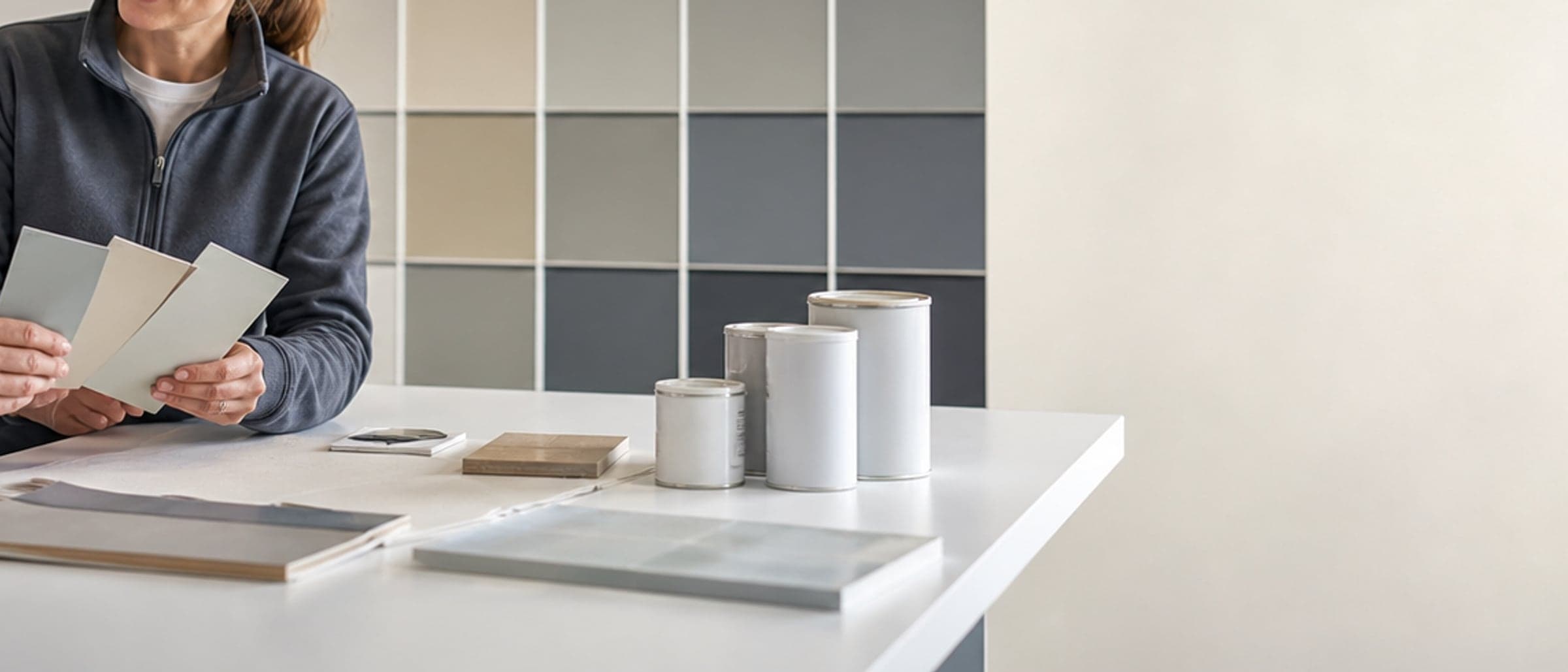 Colour cards, sample pots, sample boards and paperwork laid out on a consultation bench